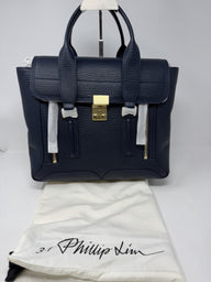 3.1 Phillip Lim Pashli medium satchel in navy pebbled leather, front view with the 3.1 Phillip Lim dust bag