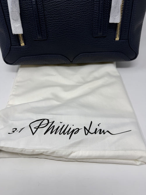 3.1 Phillip Lim Pashli medium satchel in navy pebbled leather, front flap with the dust bag behind