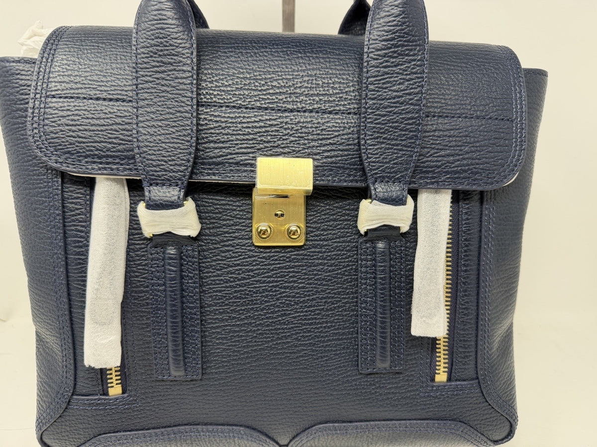 3.1 Phillip Lim Pashli medium satchel in navy pebbled leather, front view showing the push-lock and front zips