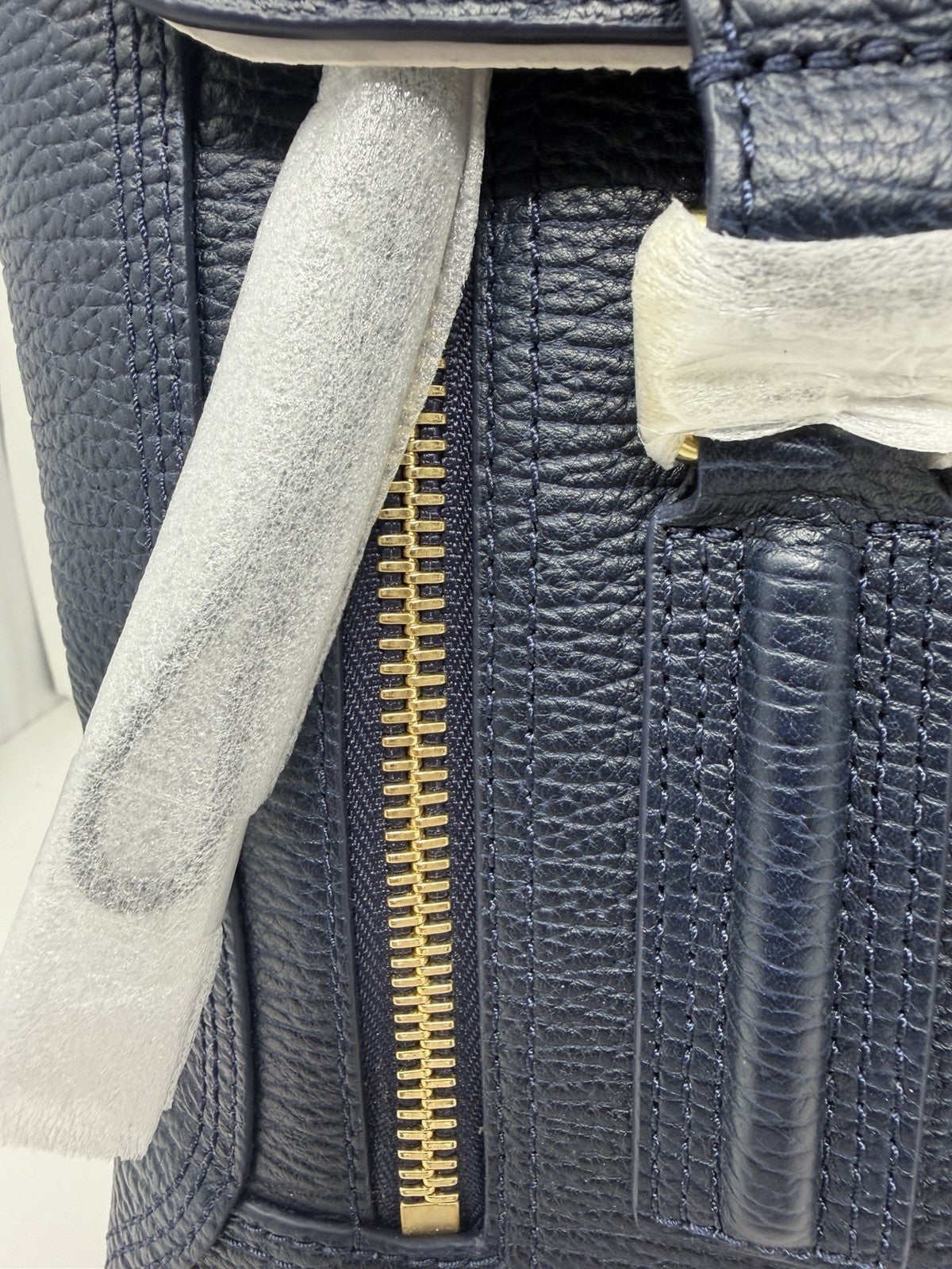3.1 Phillip Lim Pashli medium satchel in navy pebbled leather, close-up of a front gold-tone zip