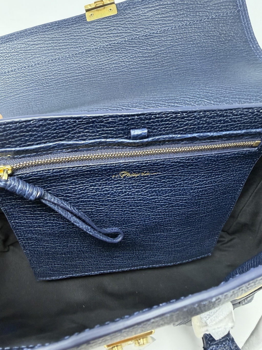 3.1 Phillip Lim Pashli medium satchel in navy pebbled leather, flap open showing the interior pocket
