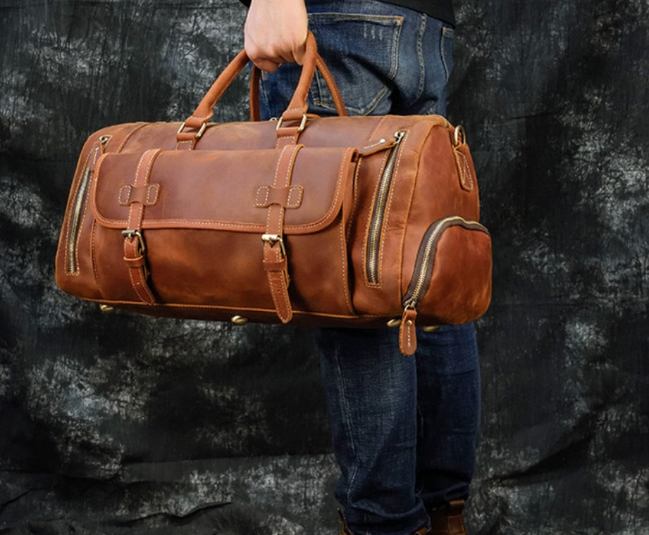 Red Brown leather travel bag carried by the top handles