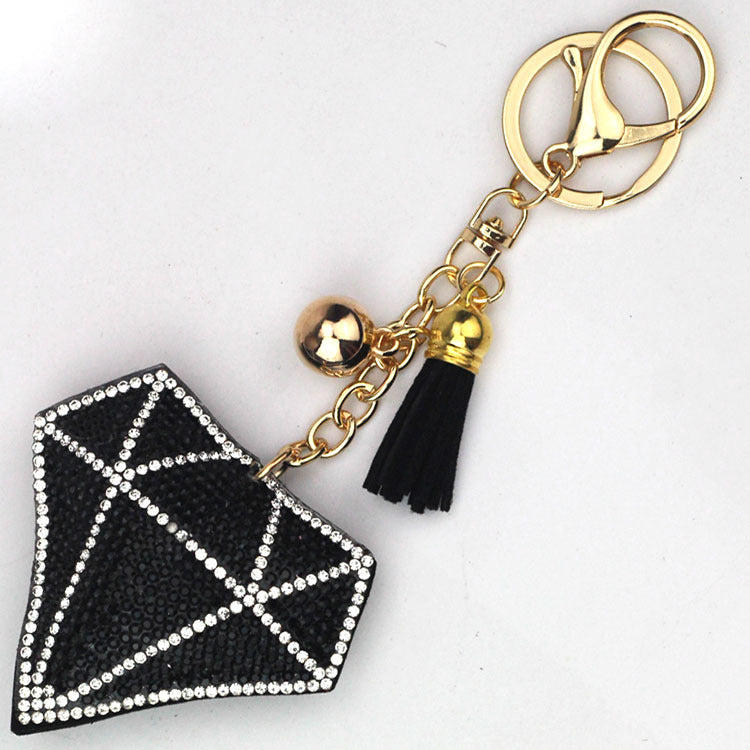Black diamond-shaped bag charm with tassel, bell and gold-tone key rings