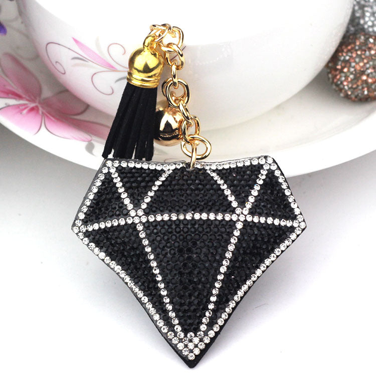 Black diamond-shaped bag charm with black tassel and gold-tone ring