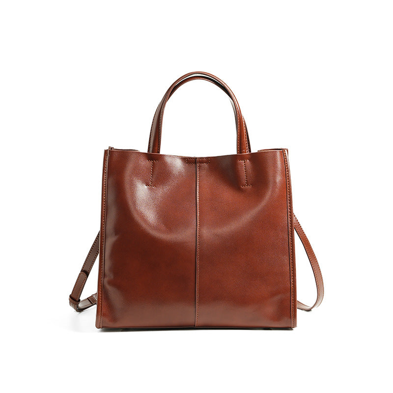 Soft cowhide leather handbag in Wine Brown, front view with shoulder strap