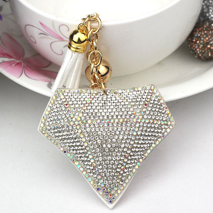 White diamond-shaped bag charm with white tassel and gold-tone ring