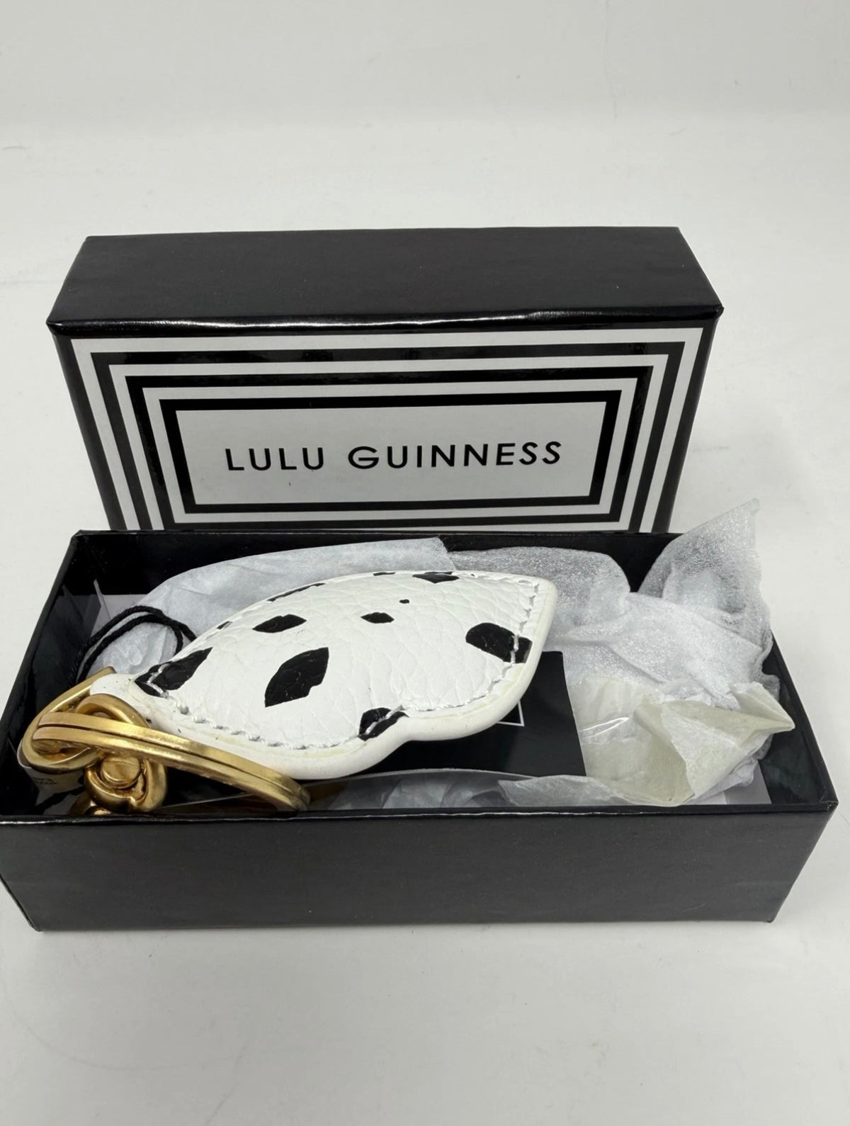 Lulu Guinness lips and leather keyring and bag charm with bold lips design, attached to a ring and chain, on a neutral background.