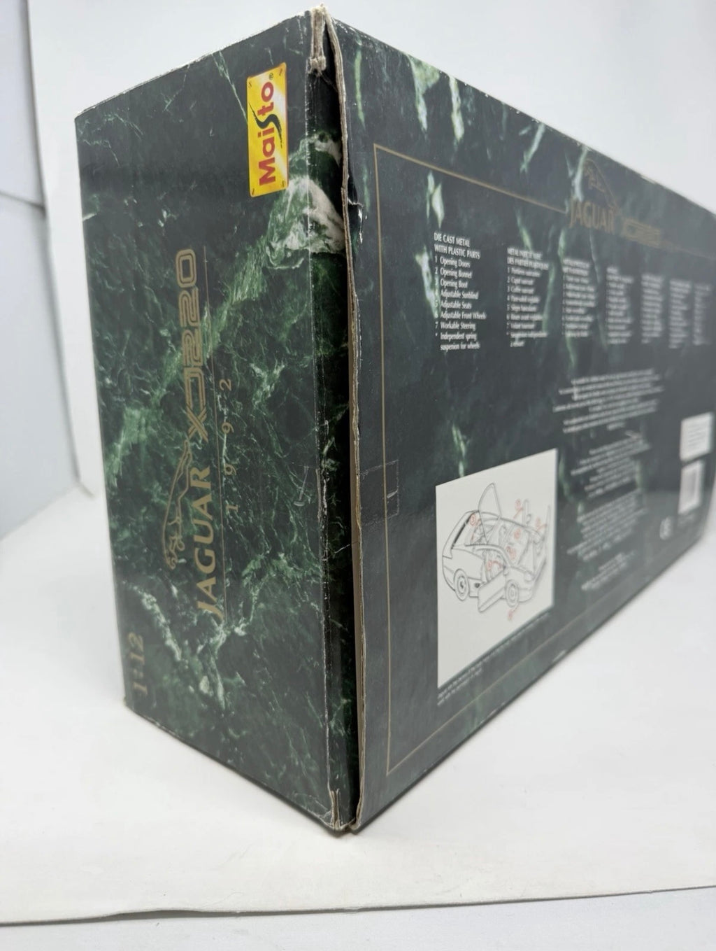 Silver Maisto Jaguar XJ220 1992 diecast model car with detailed features, displayed alongside its original box.