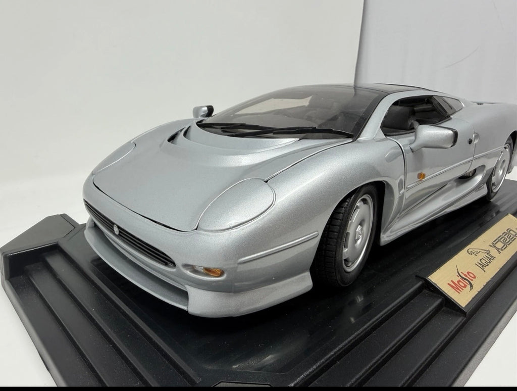 Silver Maisto Jaguar XJ220 1992 diecast model car, 1:12 scale, detailed scale model with original box visible in the image.