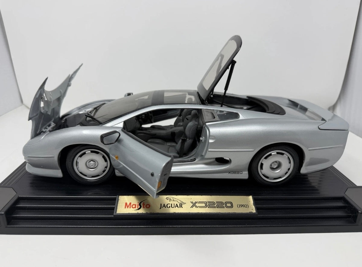 Maisto Jaguar XJ220 1992 diecast model car in silver, detailed 1:12 scale with original box, perfect for collectors and enthusiasts.