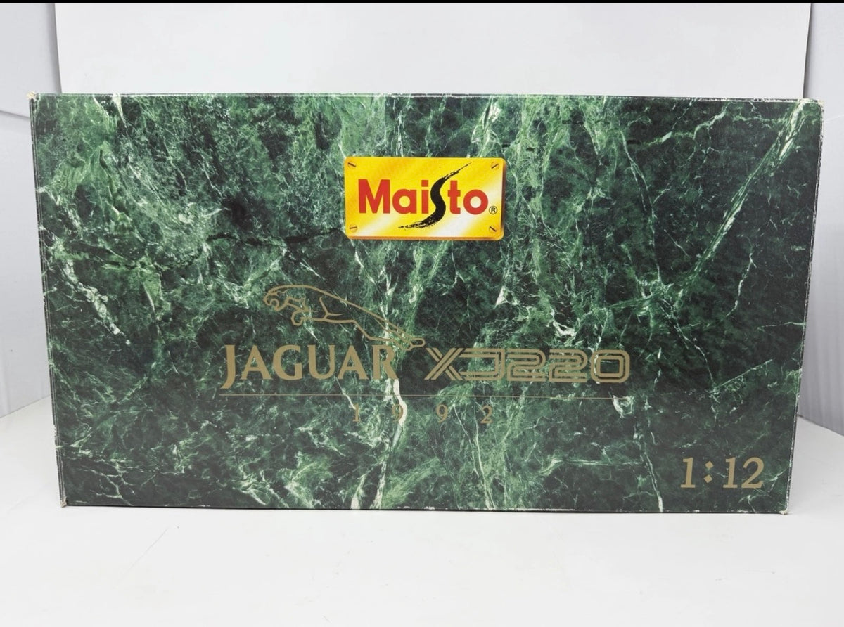 Silver Maisto Jaguar XJ220 1992 diecast model car with detailed features, displayed outside its original box.