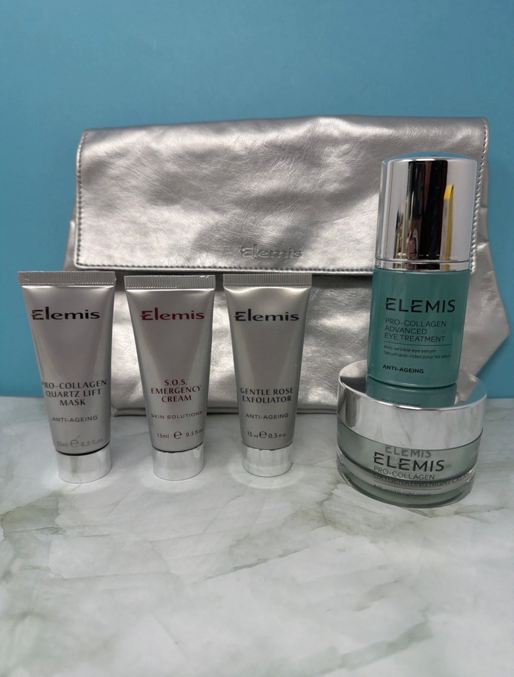 Elemis Pro-Collagen skincare gift set with multiple products and a silver cosmetic bag, displayed on a white background.
