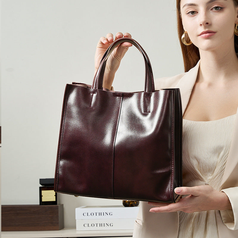 Soft cowhide leather handbag in Wine Coffee held by the handles