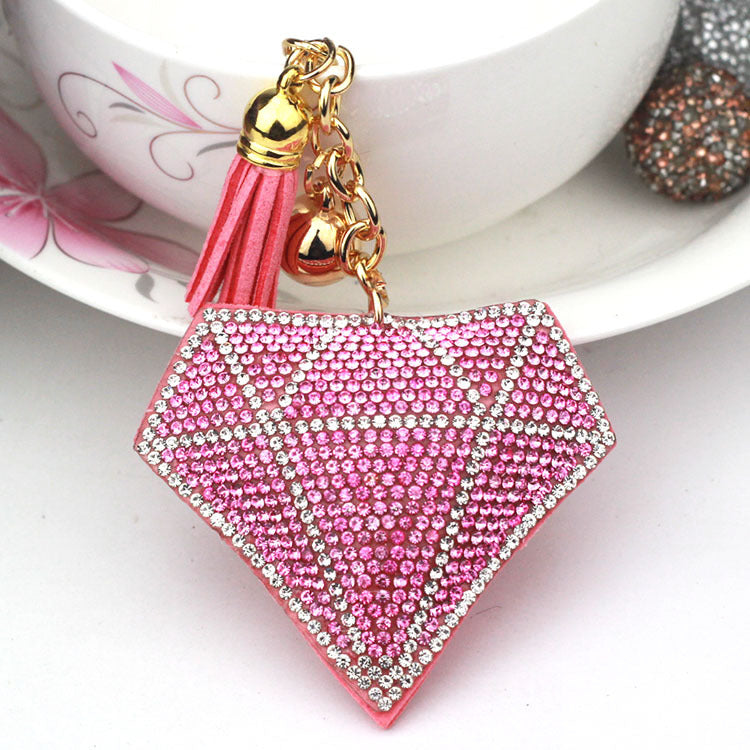 Pink diamond-shaped bag charm with pink tassel and gold-tone ring