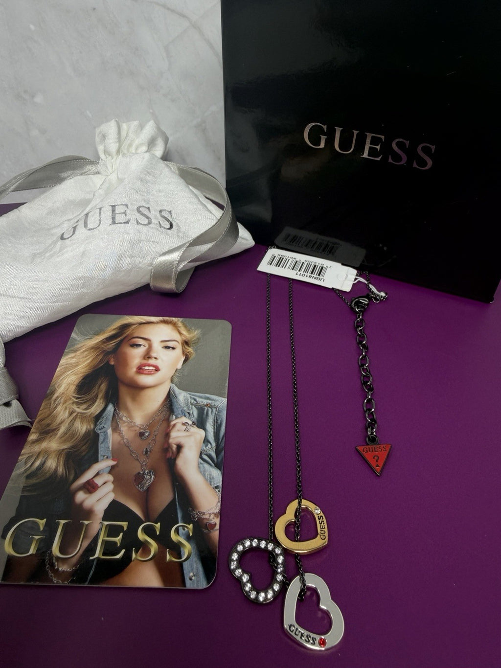 Guess Multi Heart Charm Pendant Necklace with series VII Spring 2011 tags, box, and pouch, featuring multiple heart charms.