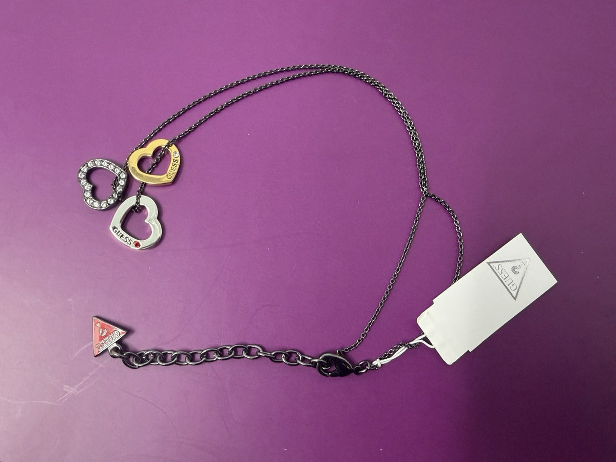 Guess Multi Heart Charm Pendant Necklace featuring multiple heart charms on a chain, with tags, box, and pouch.