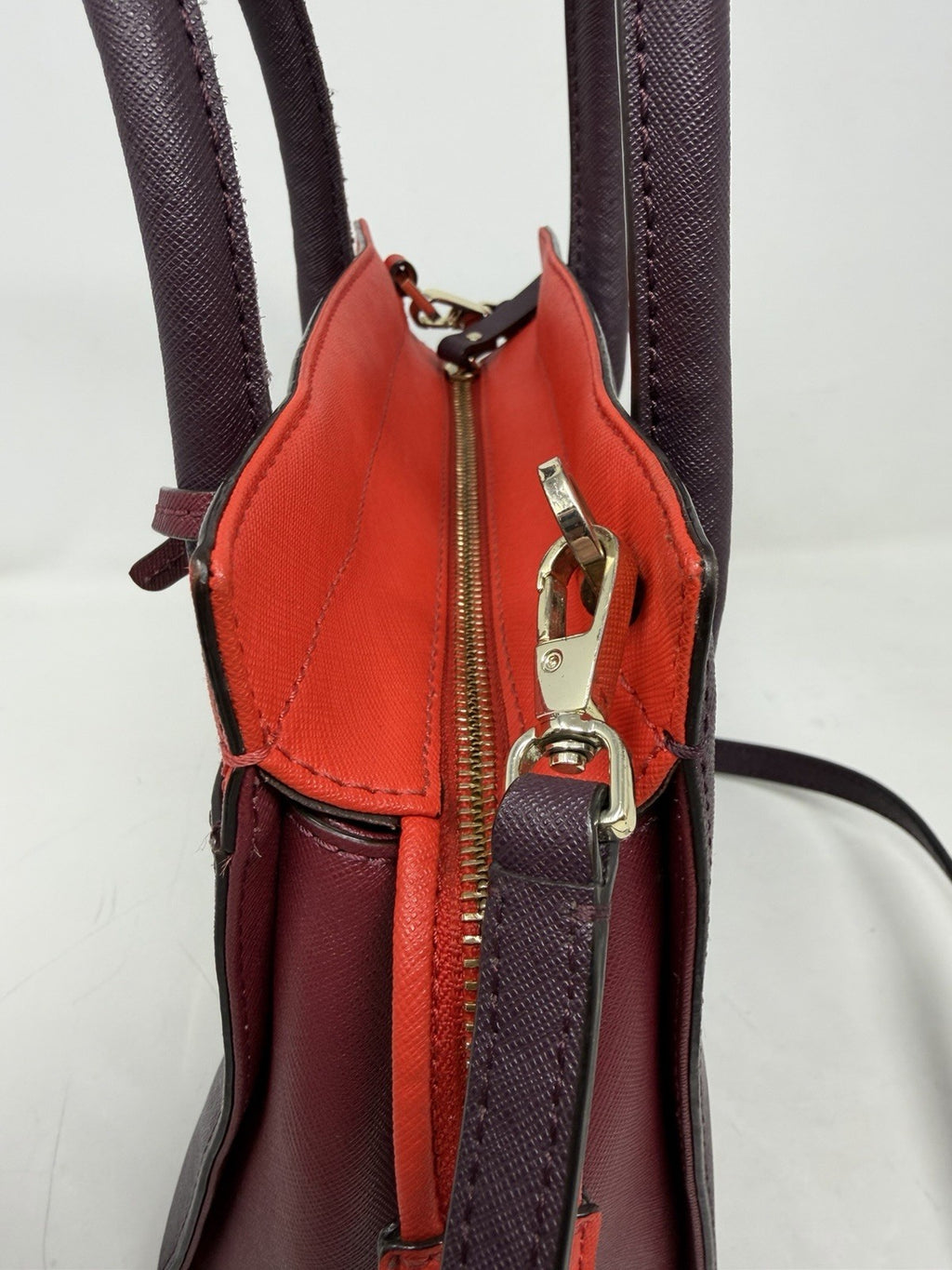 Kate Spade New York small Cameron satchel in burgundy and red saffiano leather with gold hardware, featuring a structured design.