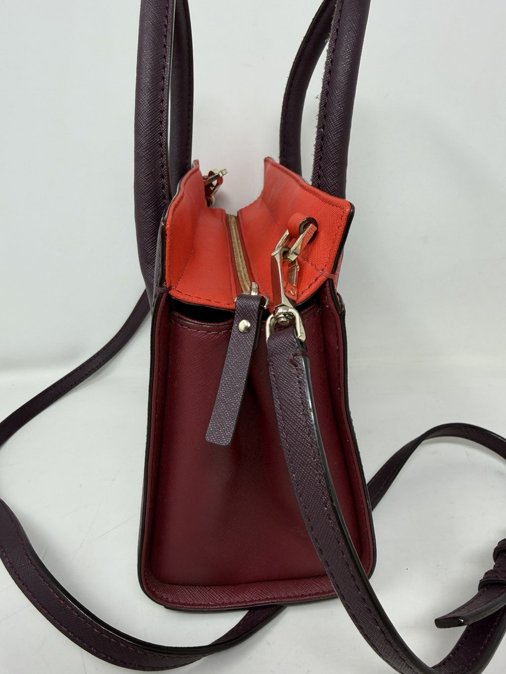 Kate Spade New York Small Cameron Saffiano leather satchel in burgundy and red, showing the structured handbag with top handles.