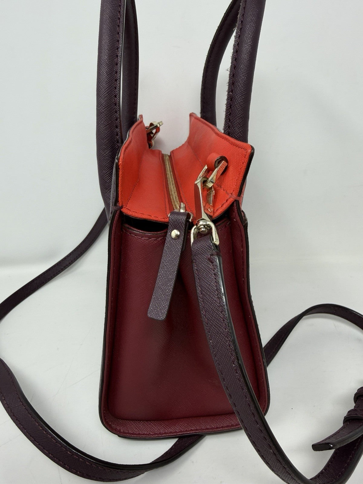 Kate Spade New York Small Cameron Saffiano leather satchel in burgundy and red, showing the structured handbag with top handles.