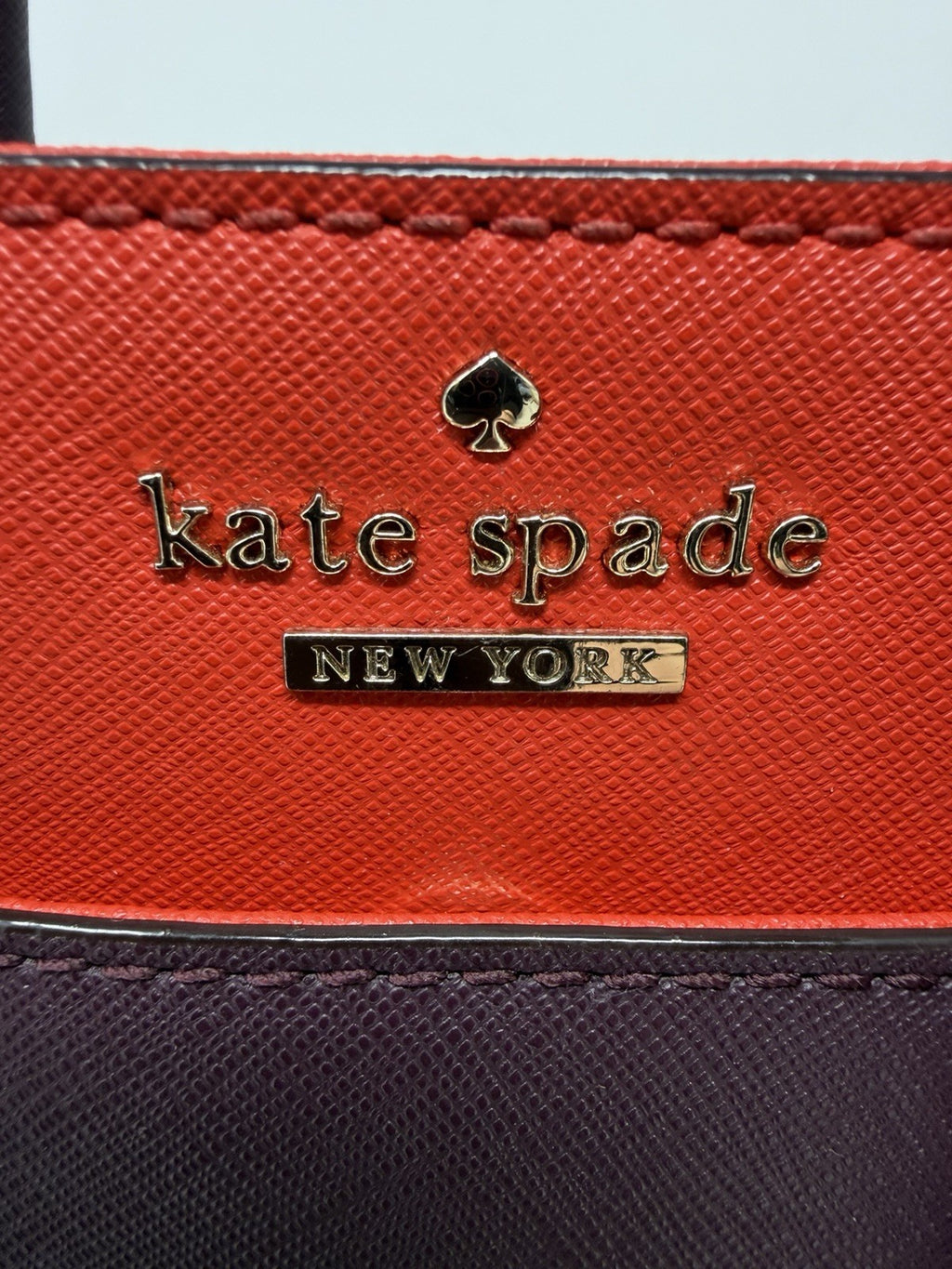 Kate Spade New York Small Cameron Saffiano leather satchel in burgundy and red, featuring a structured design and top handle.