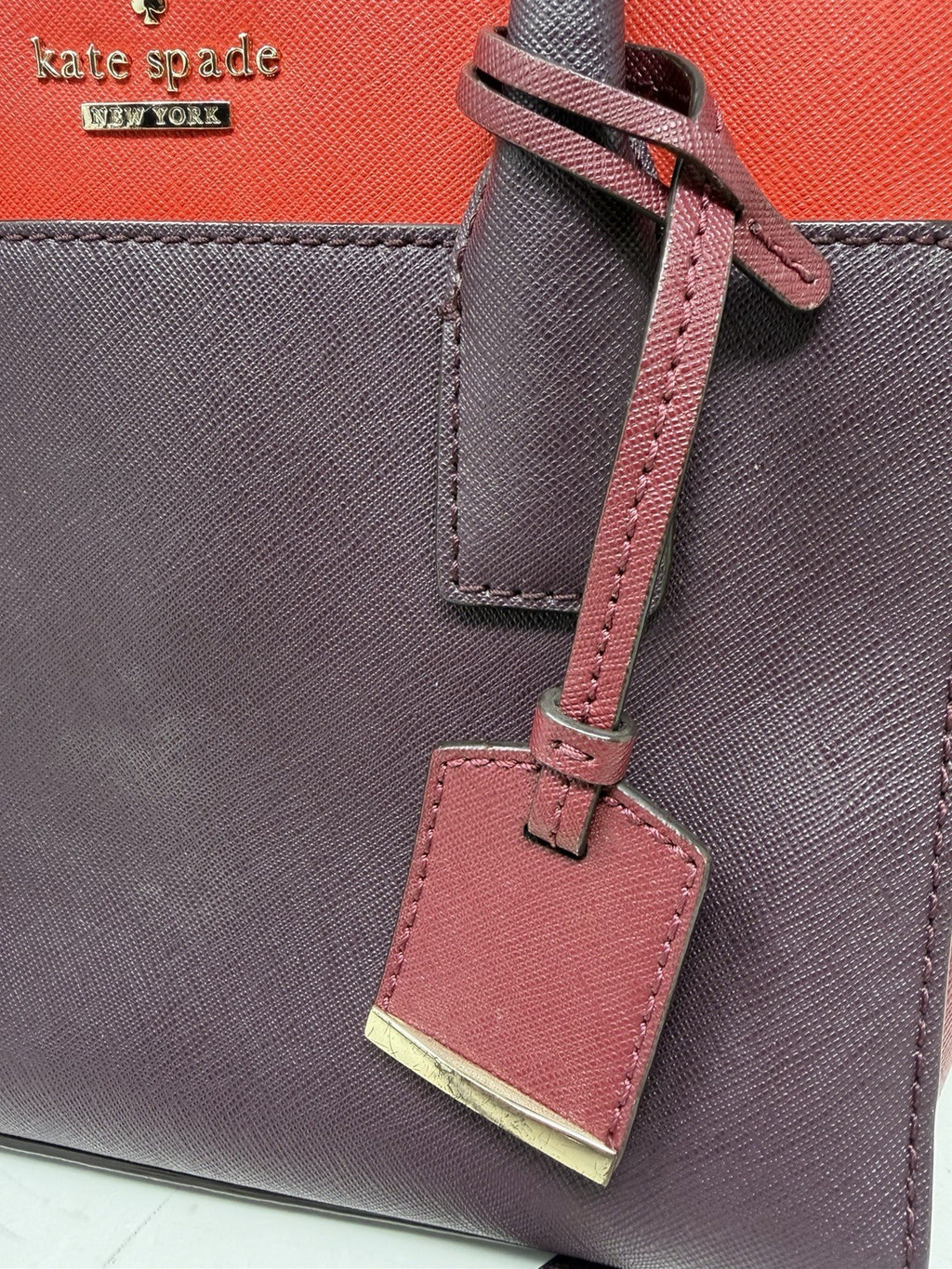 Kate Spade New York Small Cameron leather satchel in burgundy and red, showing the structured saffiano leather design.