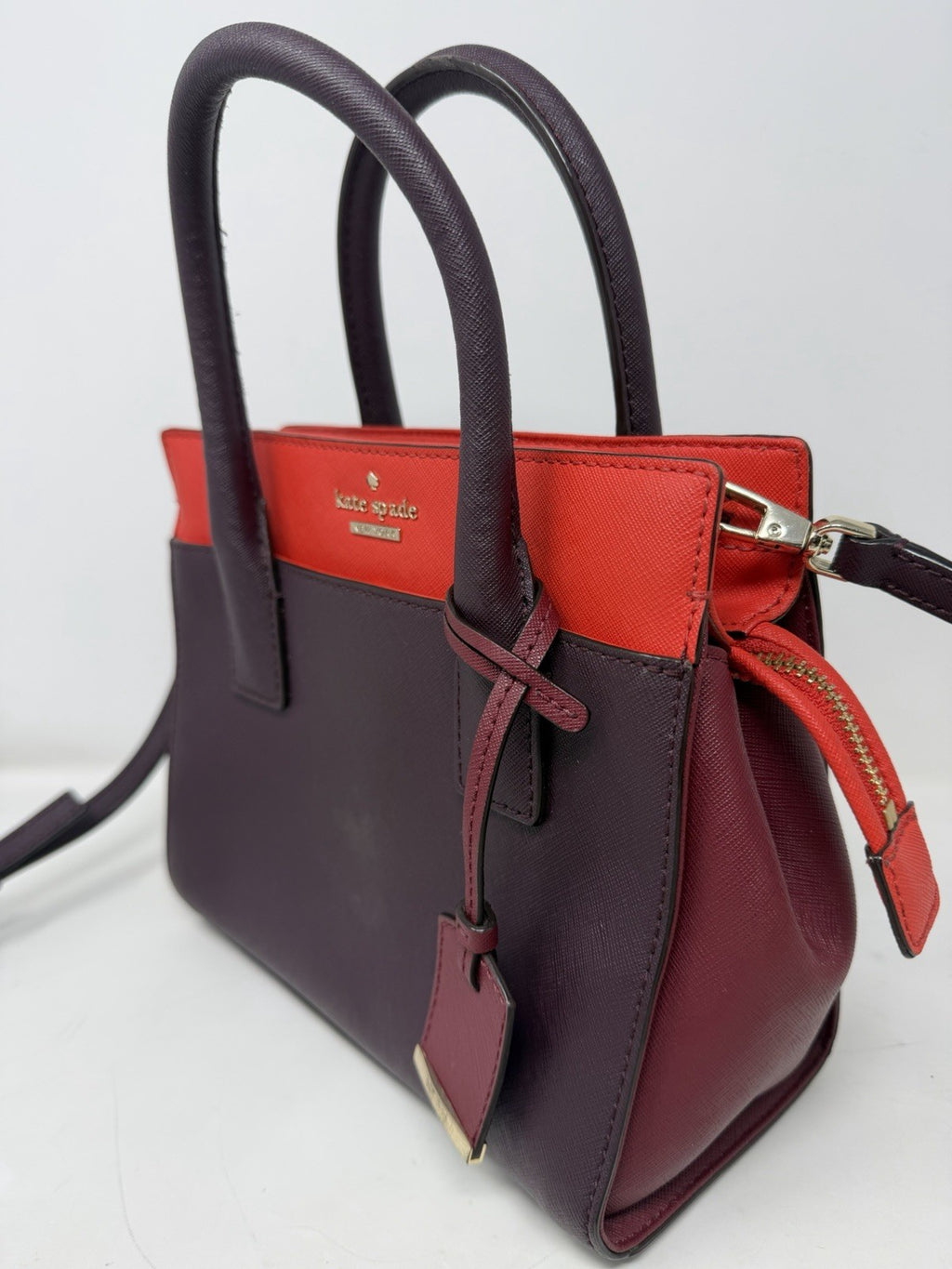 Kate Spade New York small Cameron satchel in burgundy and red saffiano leather with top handles and gold-tone hardware.