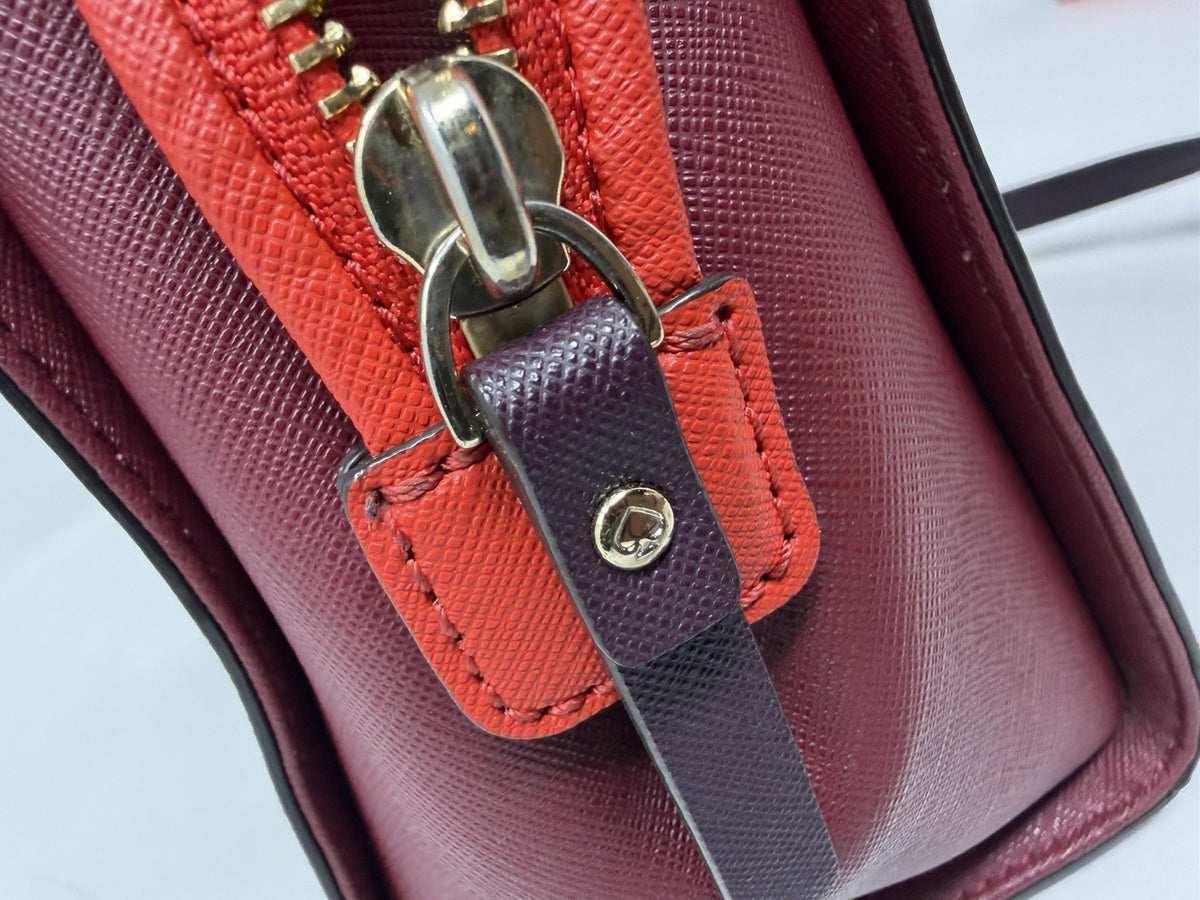 Kate Spade New York Small Cameron Saffiano leather satchel in burgundy and red, showcasing its structured design and gold-tone hardware.
