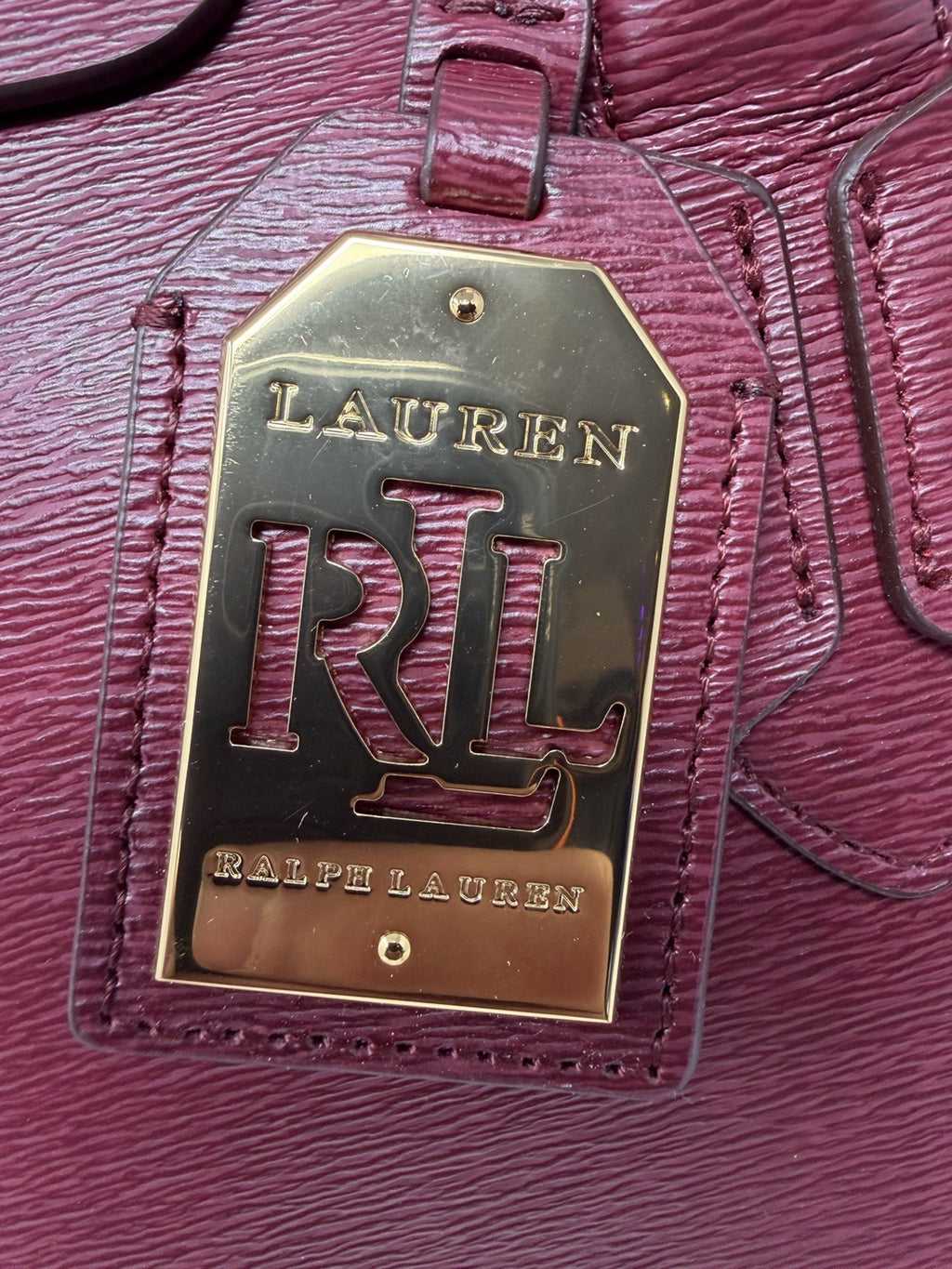 Close-up of the gold-tone RLL leather hang tag on the rosewood tote