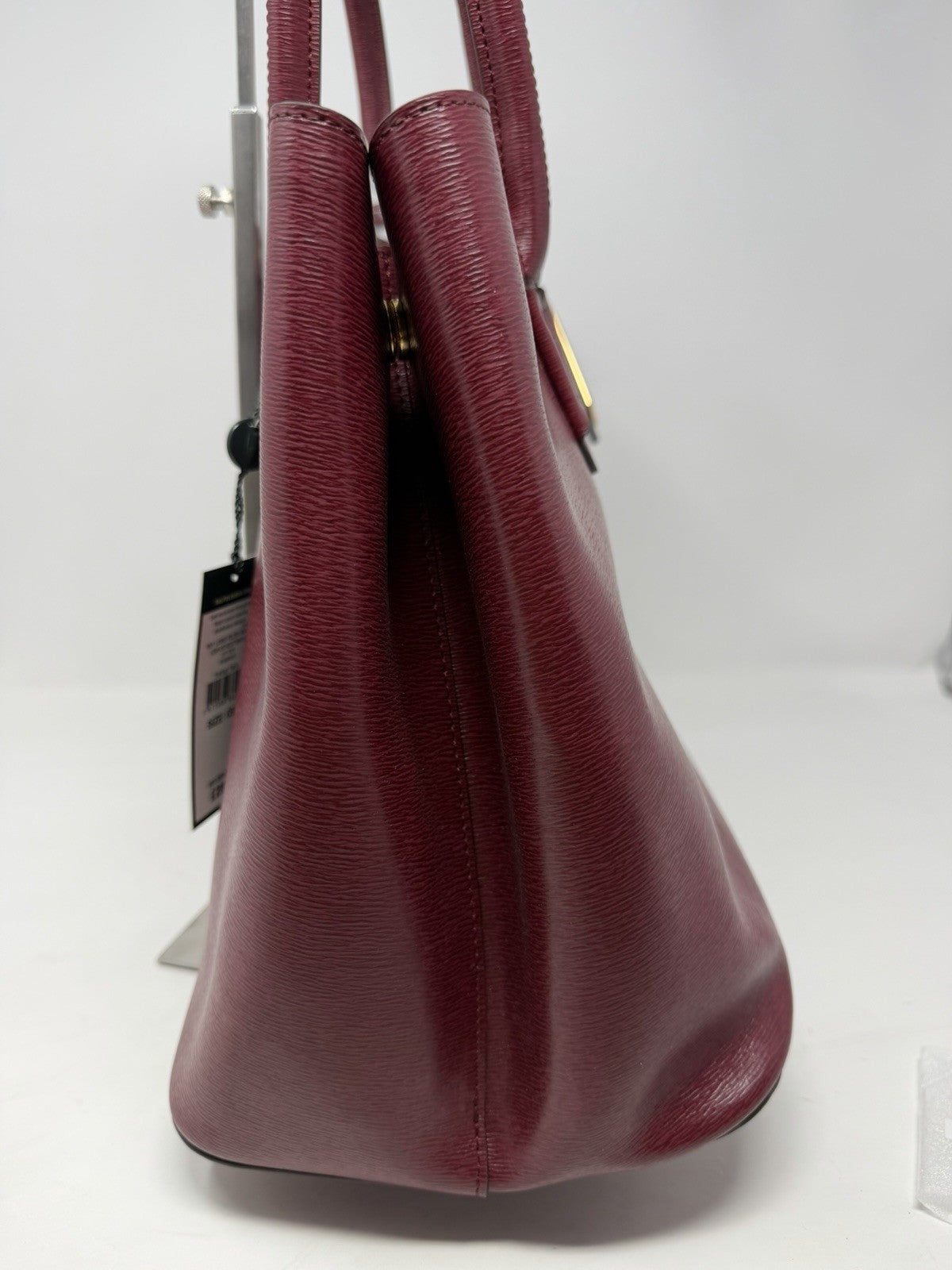 Angled side view of the rosewood leather City Tote