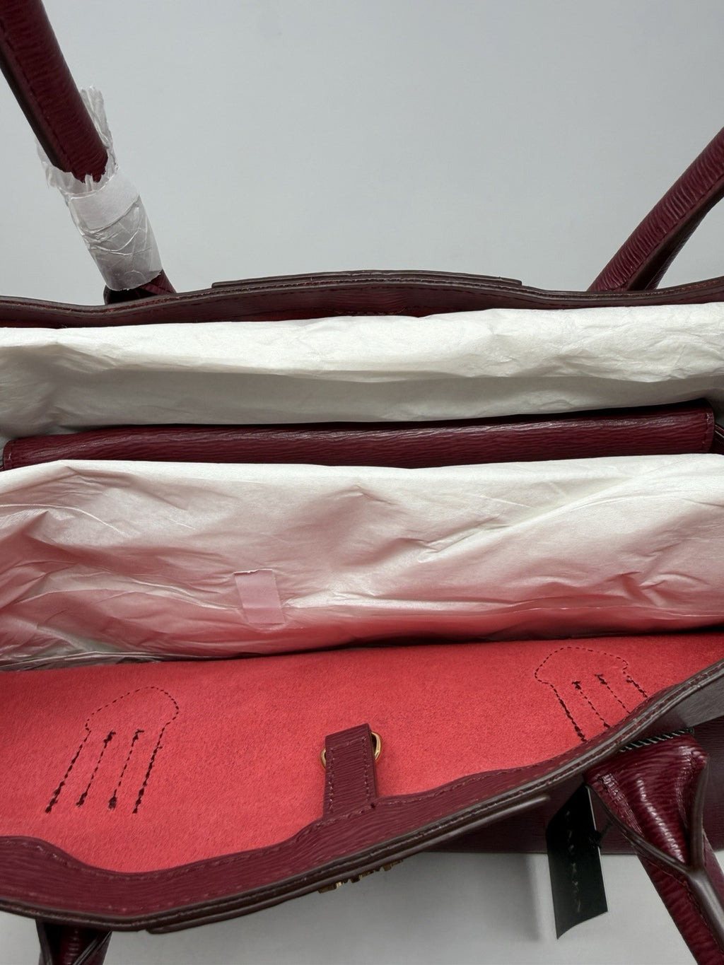 Top of the rosewood City Tote opened to show the red lining and tissue packing