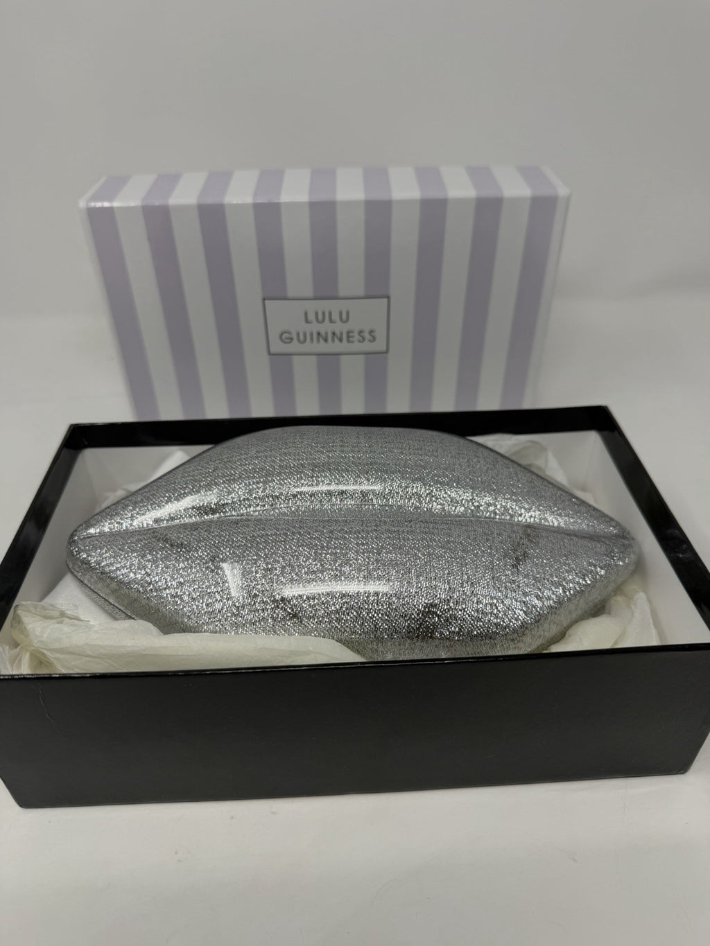Lulu Guinness silver Perspex Lip Clutch, clutch sitting in its open box