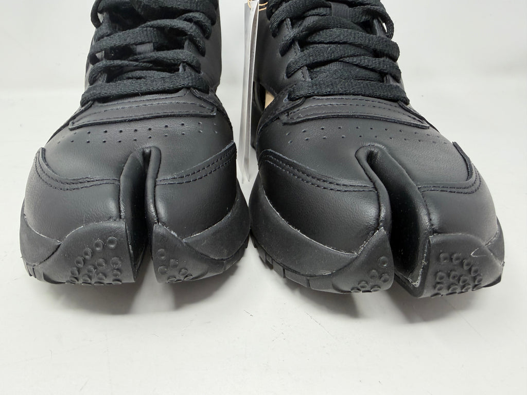 Maison Margiela × Reebok Classic Leather Tabi High black trainers, UK 6.5, featuring sleek leather design and distinctive split-toe detail.