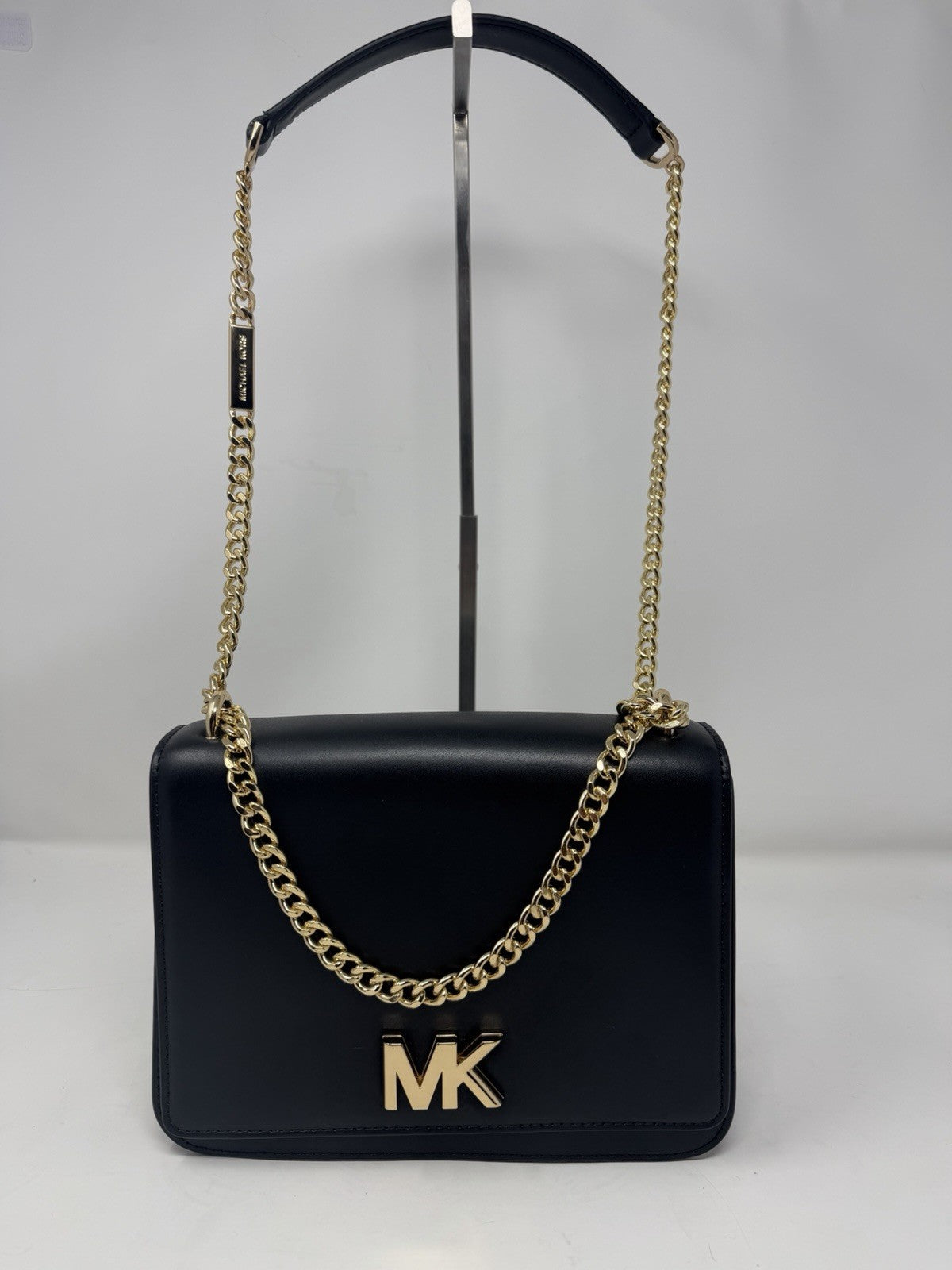 Michael Kors Mott large chain shoulder bag in black leather, front view on a stand with chain strap