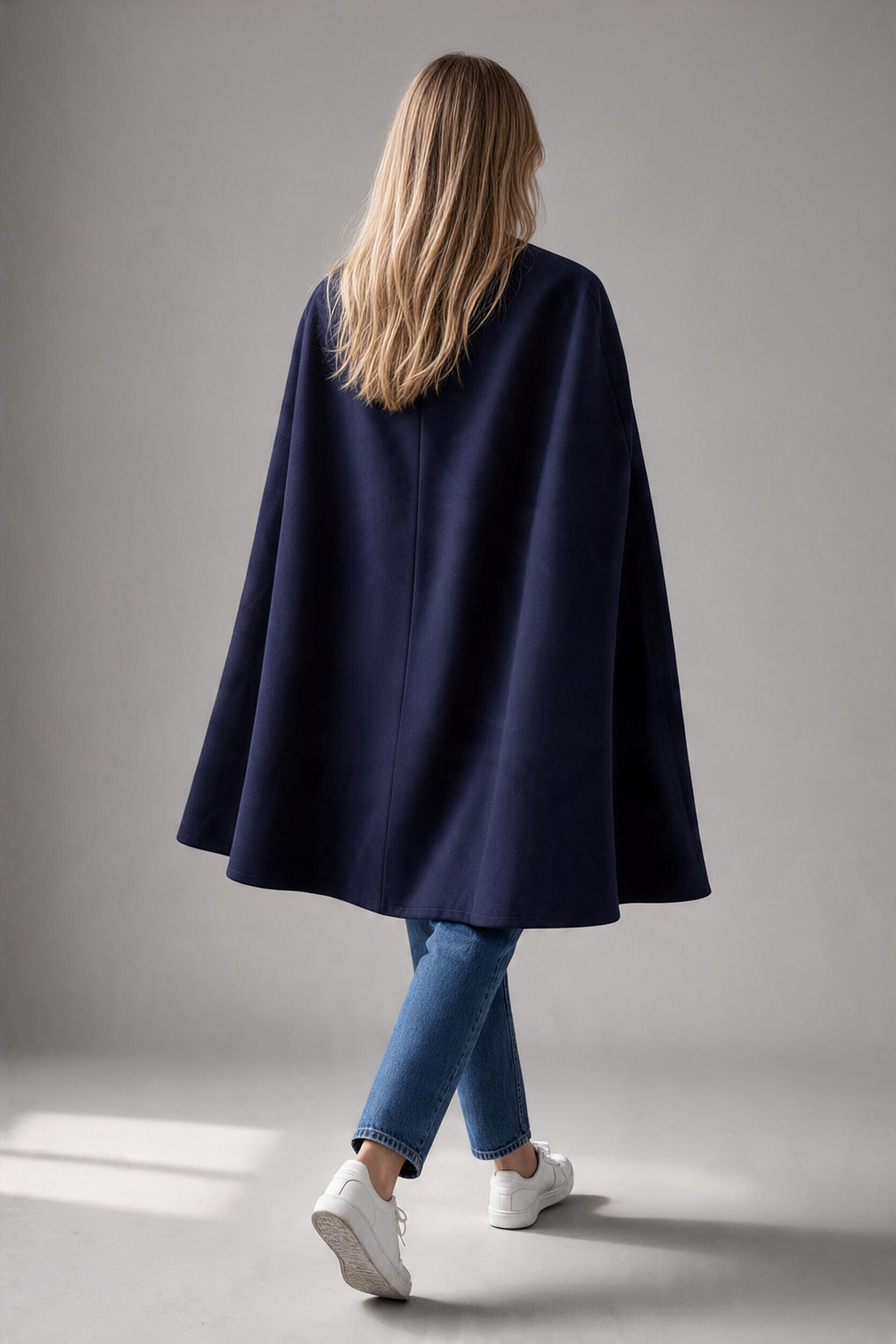 Ted Baker Vickiye navy wool and cashmere cape draped over a hanger, showcasing its elegant design and cozy fabric.